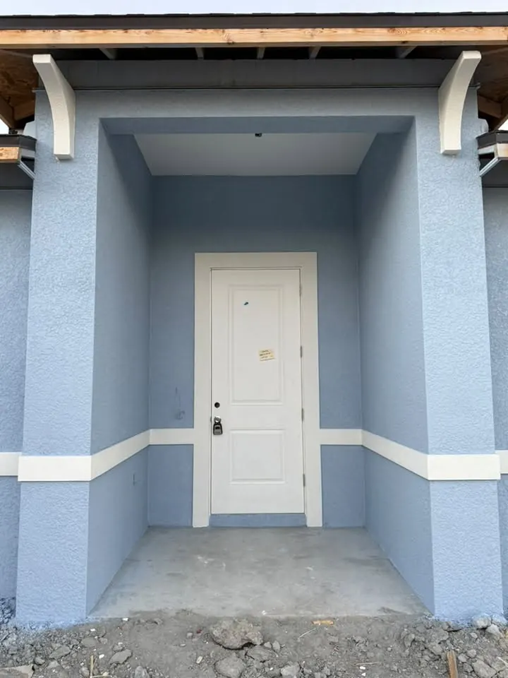 Painted blue entry with white trim band and white door